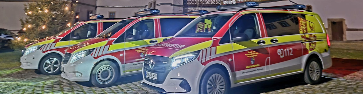 ftz-fahrzeuge Drei Einsatzfahrzeuge in rot-gelber Farbgebung, mit Blaulicht auf dem Dach, stehen nebeneinander. Auf der Seite steht '112'.